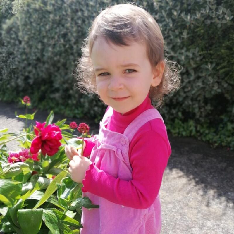 Síofra (2) enjoying the peony roses in the garden of her home in Raheny, Co Dublin. Photograph: Alma Walsh and Andrew Croughan