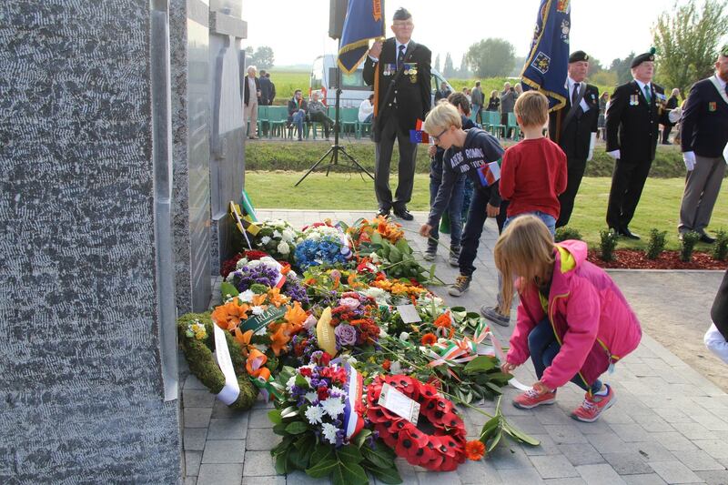 Children read the wreaths at Le Pilly memorial. Photograph: Ronan McGreevy