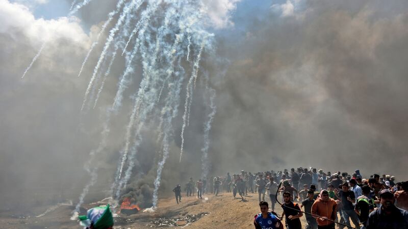 Palestinians run for cover from tear gas fired by Israeli forces near the border between the Gaza strip and Israel east of Gaza City on May 14th, 2018. Photograph: Mahmud Hamsmahumd/AFP/Getty