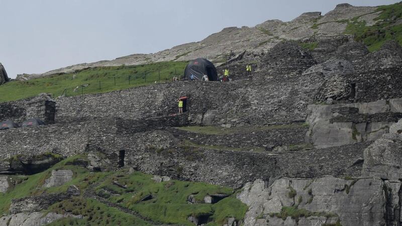 ‘It takes a brave voice –  or three –  to question authorisation for activity which is said to have Portmagee “buzzing”, which has the Naval Service patrol ship LE Samuel Beckett policing a two-mile exclusion zone at sea, and which will ensure that Skellig Michael becomes another “cinema classic” location.’ Above, production crew and sets on Skellig Michael   as Star Wars Episode VII directed by JJ Abrams began filming earlier this week. Photograph: Charles McQuillan/Getty Images