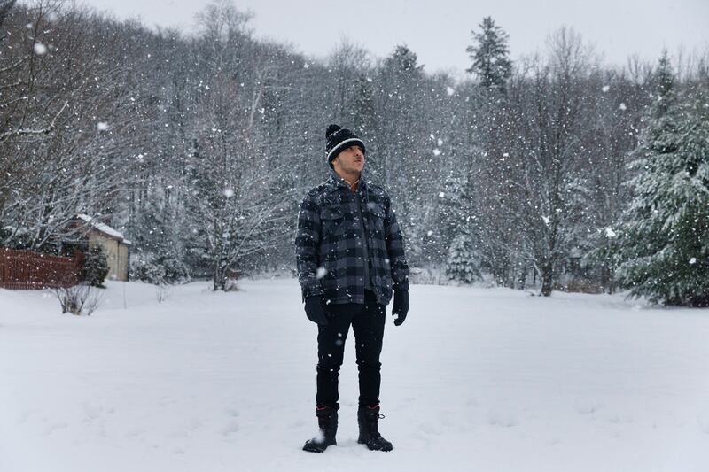 Abdelkarim Othmani, from Tunisia, near his apartment in St-Tite, Quebec. Othmani says he doesn't mind the snow, and prefers the tranquility of the small town to the city. Photograph: Nasuna Stuart-Ulin/New York Times