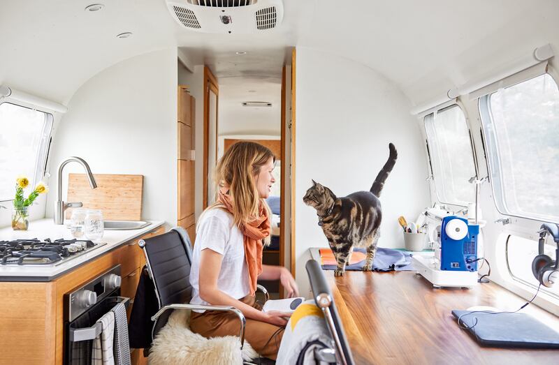 Quiltmaker Laura Preston with her cat Papa in her 1990 Airstream in California. Photograph: Sian Richards