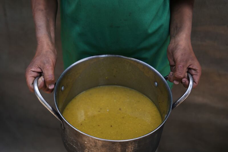 A Palestinian child carries a pot of soup received from a community kitchen. Photograph: Abdel Kareem Hana/AP