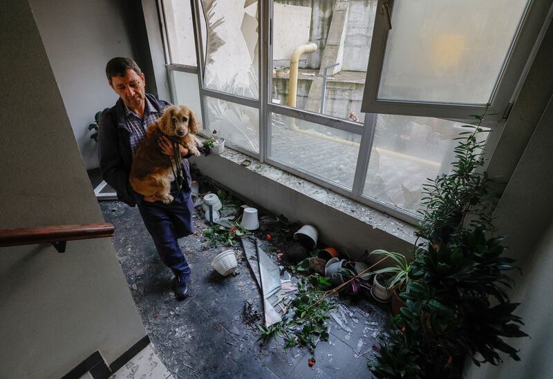 A local man carries his dog at a damaged stairwell after a drone strike on a residential building in Kyiv on Monday. Photograph: Sergey Dolzhenko/EPA
