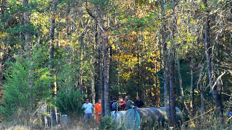 Todd Kohlhepp, in handcuffs and an orange jumpsuit, is escorted by deputies on his property in Woodruff, South Carolina on Saturday. Photograph: Heidi Heilbrunn//The Greenville News via AP