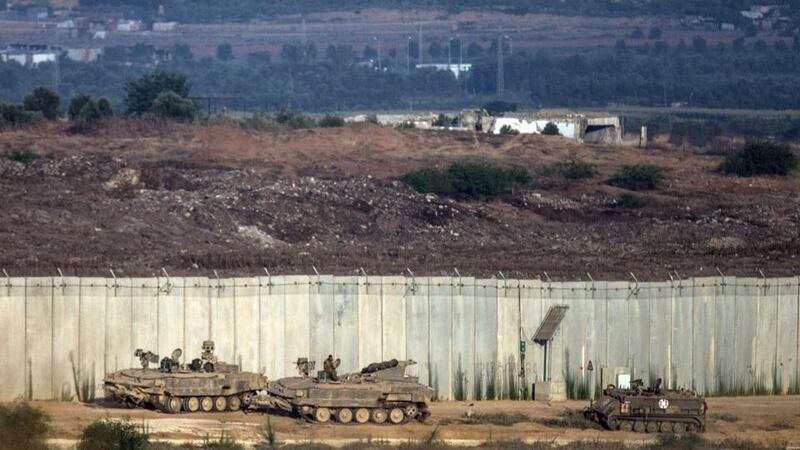 Israeli tanks sit at  the wall seperating Gaza and Israel  near Sderot this morning. Photograph:  Andrew Burton/Getty Images
