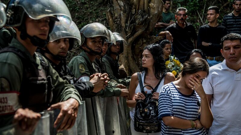 Government security forces block mourners from entering the burial site of José Alejandro Díaz Pimentel and Abraham Agostini, rebels who were killed along with their leader Óscar Pérez by government forces, in El Hatillo, Venezuela, on Saturday. Photograph:  Meridith Kohut/The New York Times