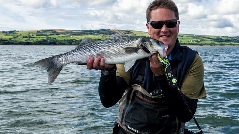 Henry Gilbey, angling photographer, journalist and broadcaster with a good-sized bass.