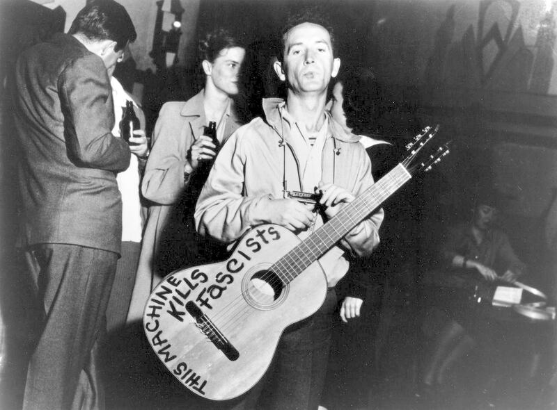 This machine kills fascists: Woody Guthrie with his guitar