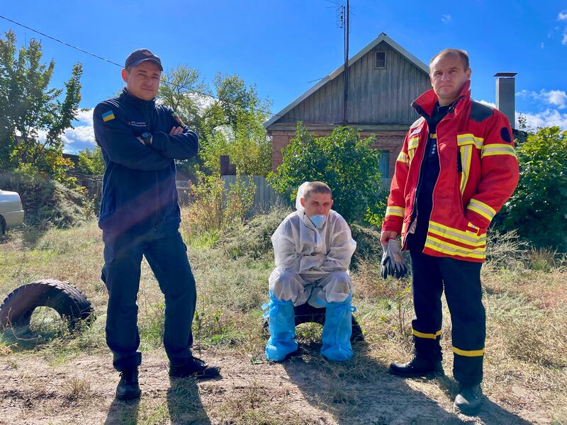 
A forensic worker and two policemen rest during exhumation work at the mass grave in Izyum, eastern Ukraine. Photograph: Daniel McLaughlin