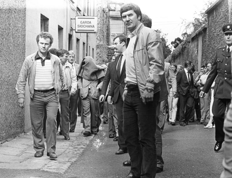 Malcolm Macarthur is brought to Dún Laoghaire District Court, his head covered by a blanket, in August 1982. Detective Sergeant Tony Hickey is immediately behind Macarthur to his left. Photograph: Eddie Kelly