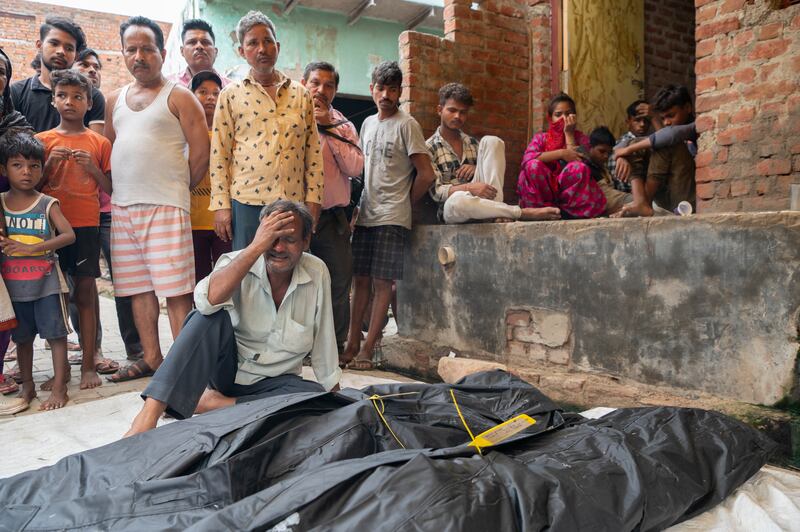 Vinod Kumar mourns over the bodies of his wife and daughter in Sokhana, near Hathras, India. They were among the people who died in the stampede in early July. Photograph: Saumya Khandelwal/New York Times
                      
