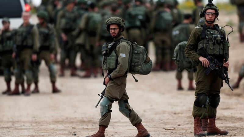 Israeli soldiers make their way to their positions at the Israeli border with Gaza next to the security fence. Photograph: EPA/ Atef Safadi