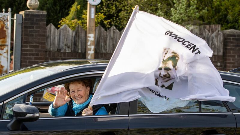 A car passing through Ballymurphy with a white flag bearing victim Edward Doherty’s picture. Photograph : Liam McBurney/PA Wire