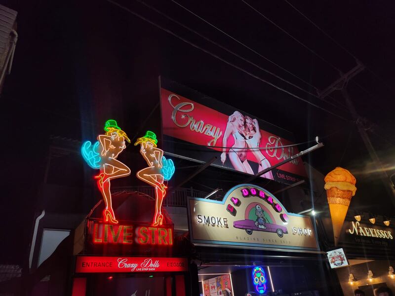 Signs advertising both strip clubs and a smoke shop on the strip in Laganas, Zante. Photograph: Niamh Browne