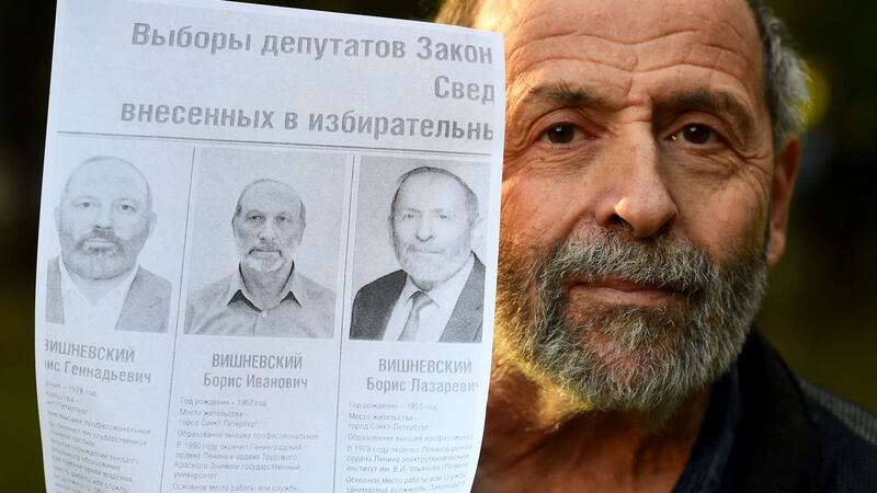 Liberal Saint Petersburg politician  Boris Vishnevsky with a mock-up of an official election poster featuring photos of him and two other Boris Vishnevskys that took part in  recent elections. Photograph: Olga Maltseva/AFP via Getty Images