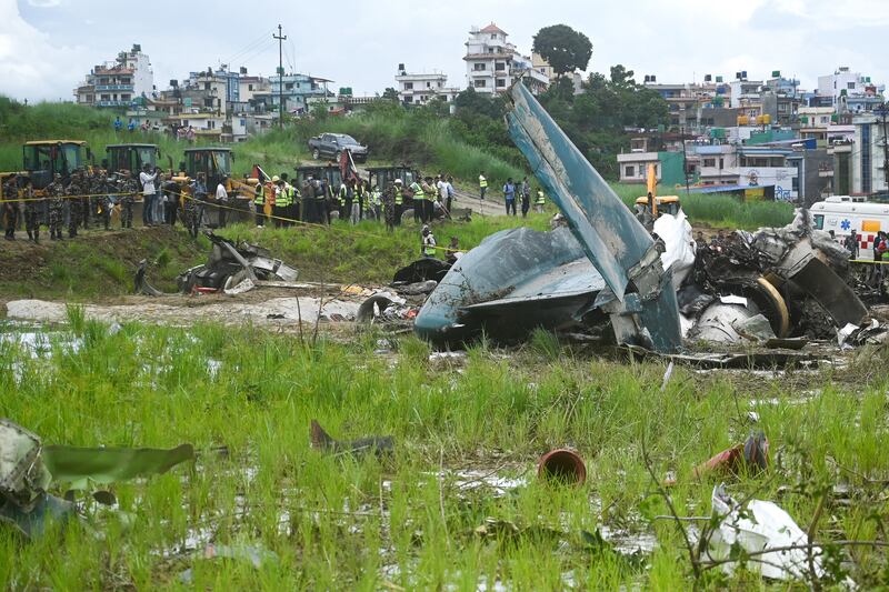 Army personnel and other officials stand around the debris. Photograph: Prakash Mathema/AFP via Getty