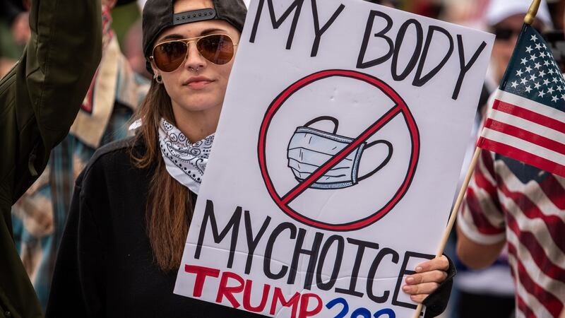 A demonstrator holds up a sign protesting wearing a surgical mask  in Austin, Texas, on Saturday. Photograph: Sergio Flores/Getty Images