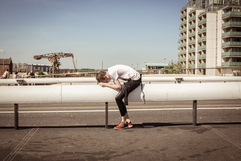 'Dog Day Afternoon'. A boy heats himself up on the metal pipe after a full day of diving and swimming. His friends can be seen preparing for the leap from the 'Rusty Bridge'. Photograph: Paul Kelly
