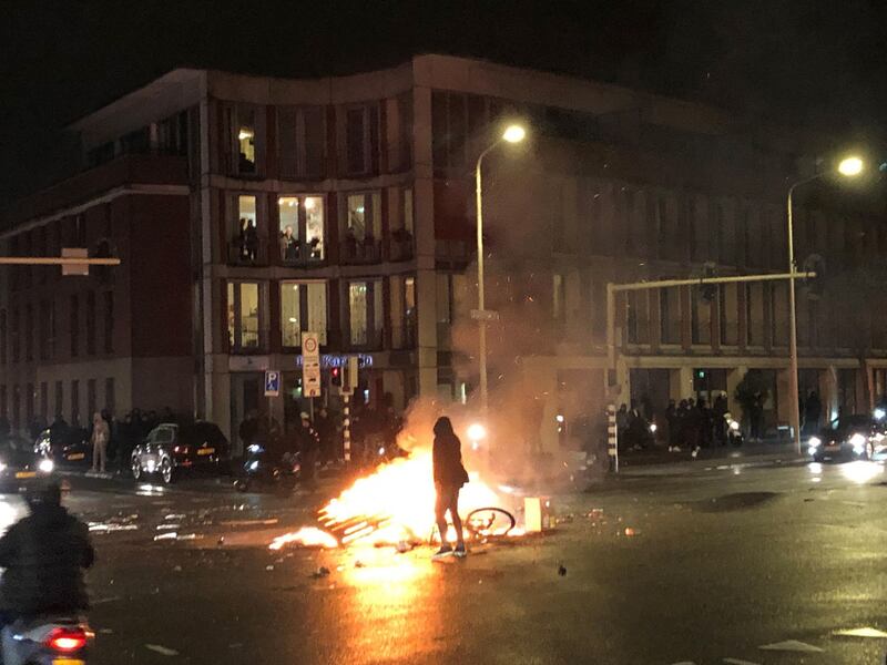 A man walks in front of a fire in a street in The Hague during a demonstration against the Dutch government’s coronavirus measures on Saturday. Photograph: Danny Kemp/AFP via Getty