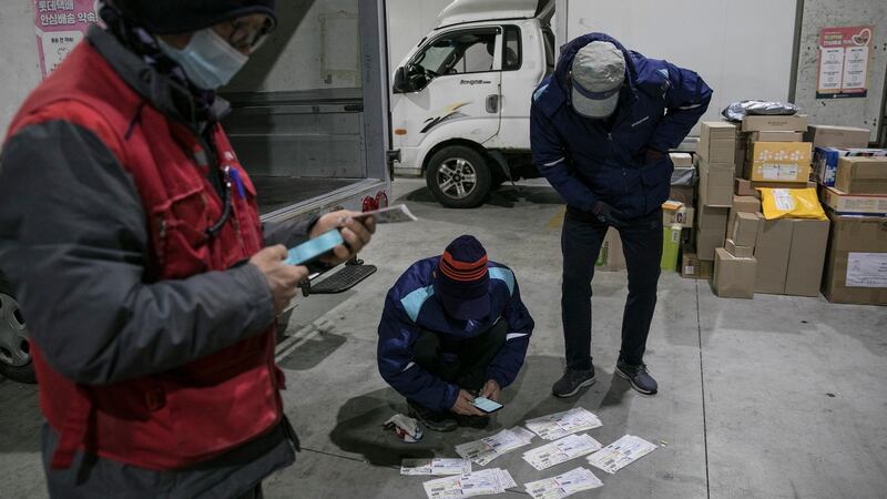 Couriers check delivery addresses at a distribution centre in Seoul. Photograph: Woohae Cho/The New York Times