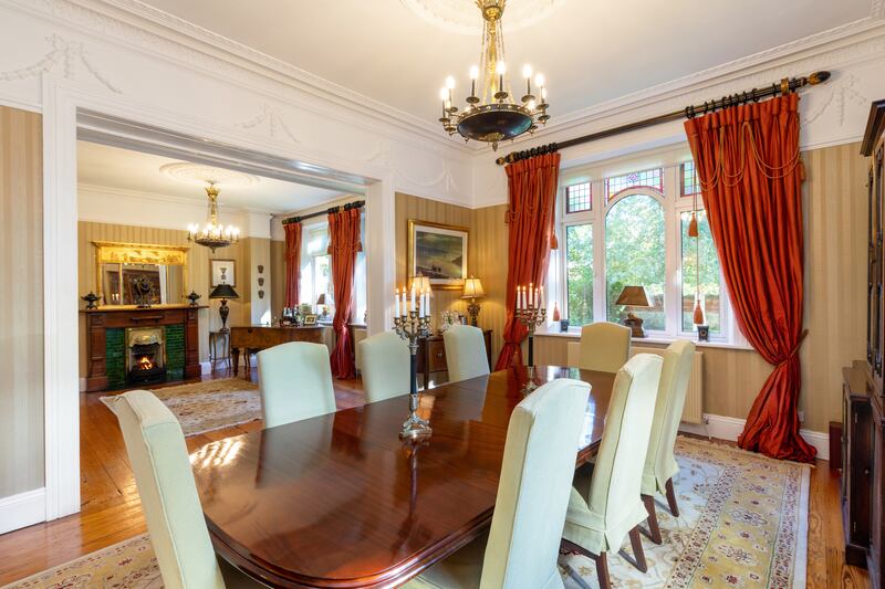 A dual-aspect dining room and a sitting room with a grand piano have tall mahogany fireplaces with tiled insets