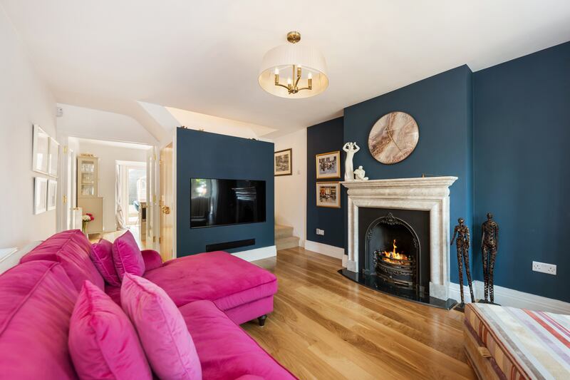 Living room with a new partition housing the television that hides the stairs