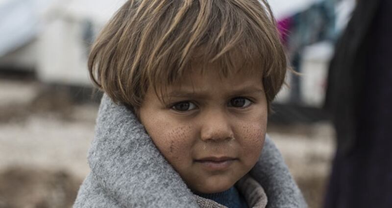 A two-year-old boy called Mahmoud is wrapped up in a blanket provided in an Oxfam winter survival box. Photograph: Sam Tarling/Oxfam