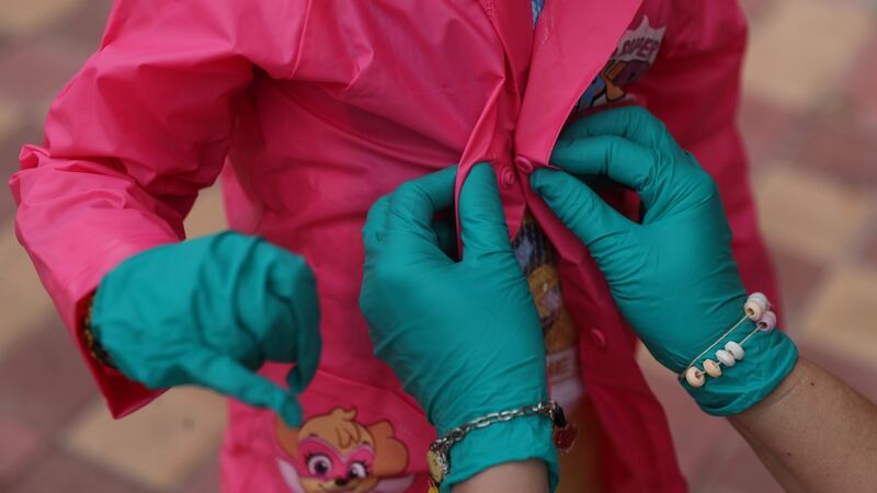 Madrid: Five-year-old Candela Estrella, wearing protective gloves, gets her mother’s help buttoning her jacket after restrictions were partially lifted for children for the first time in six weeks. Photograph: Reuters