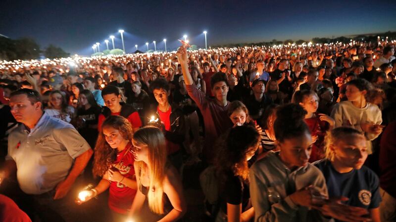 People hoist up their candles during a vigil for the victims on Thursday. Photograph: Gerald Herbert