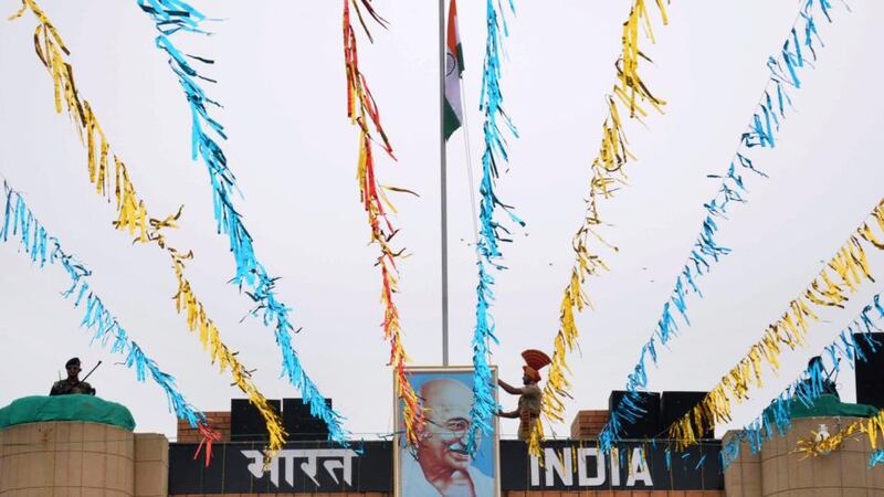 An Indian Border Security Force (BSF) soldier unfurls  Indian flag in a ceremony at the India-Pakistan Wagah border post on August 15th to celebrate India’s Independence Day. Photograph: Narinder Nanu/AFP/Getty Images