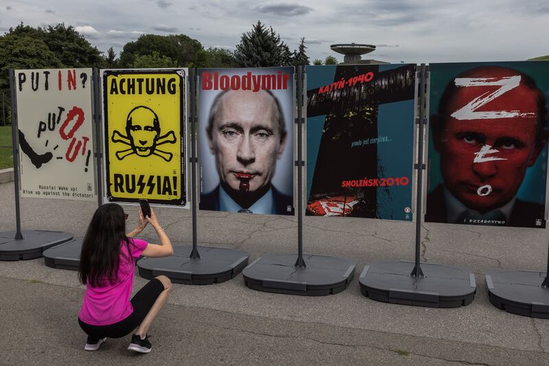 A woman takes photos of a poster with the likeness of Russian president Putin as she visits an outdoor poster exhibition titled 'The Victory Day' at the National Museum of the History of Ukraine in the Second World War in Kyiv, Ukraine. Photograph: Roman Pilipey/EPA
