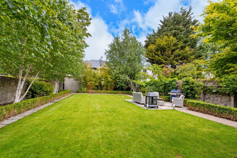 A sunny patio lies halfway down a garden path