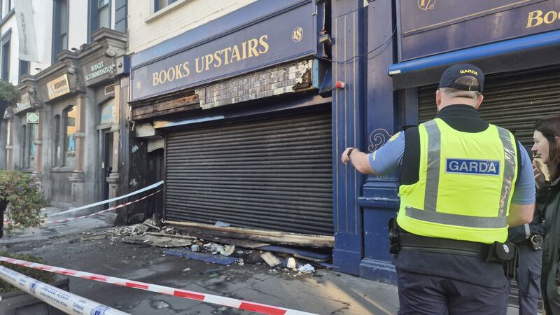 A garda stands outside the fire-damaged Books Upstairs. Photograph: Claire Murphy