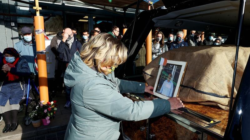 Clare Gormley placing an image of shopkeeper Akram Hussein into the hearse. Photograph: Maxpix