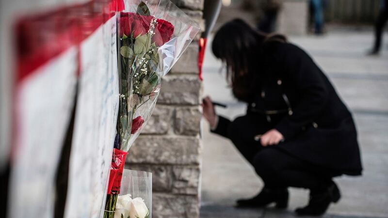 A woman writes her condolences at a makeshift memorial to the victims after a van mounted a sidewalk crashing into pedestrians in Toronto. Photograph: Aaron Vincent Elkaim/The Canadian Press via AP
