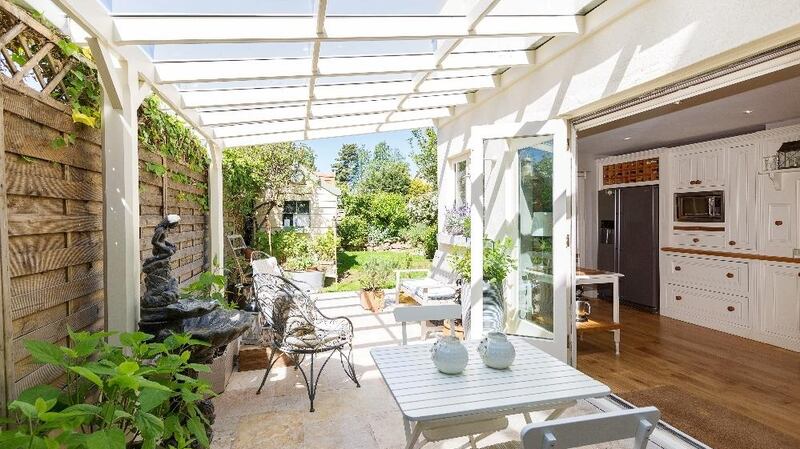The kitchen, via double glass doors,  leads to a glazed-over patio with sandstone tiles