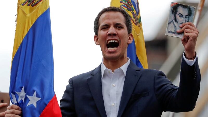 Juan Guaidó, president of Venezuela’s national assembly, holds a copy of the Venezuelan constitution during a rally against  president Nicolás Maduro’s government  in Caracas on Wednesday. Photograph: Carlos Garcia/Reuters