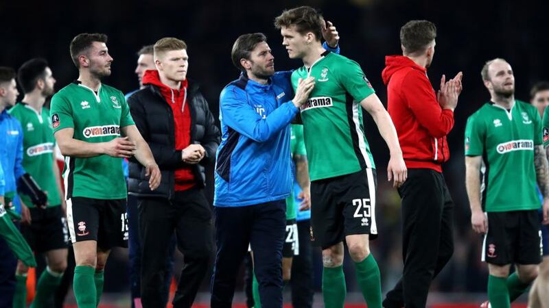 Lincoln players gather on the pitch after their loss to Arsenal. Photo: Julian Finney/Getty Images