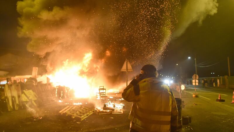 A protester watches as barricades burn, after the announcement of imminent police intervention, after ‘yellow vest’ activists blocked  access to an  oil depot in Le Mans, northwestern France, on Tuesday. Photograph: Jean Francois-Monier/AFP/Getty Images