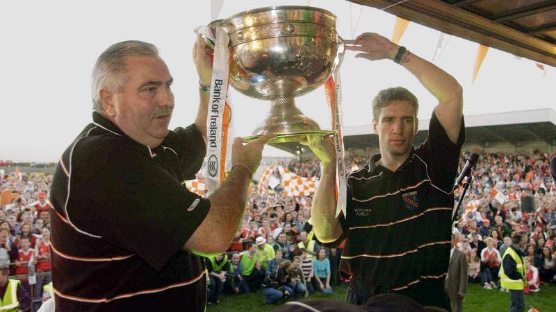 Armagh manager Joe Kernan and captain Kieran McGeeney hold the Sam Maguire cup aloft in front of Armagh fans on the team’s homecoming in Crossmaglen in 2002. File photograph: Brendan Moran/ SportsfIle