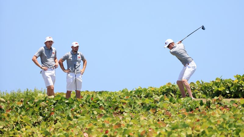 Mark Power hits a tee shot as Barclay Brown and Alex Fitzpatrick look on. Photo: Sam Greenwood/R&A/R&A via Getty Images