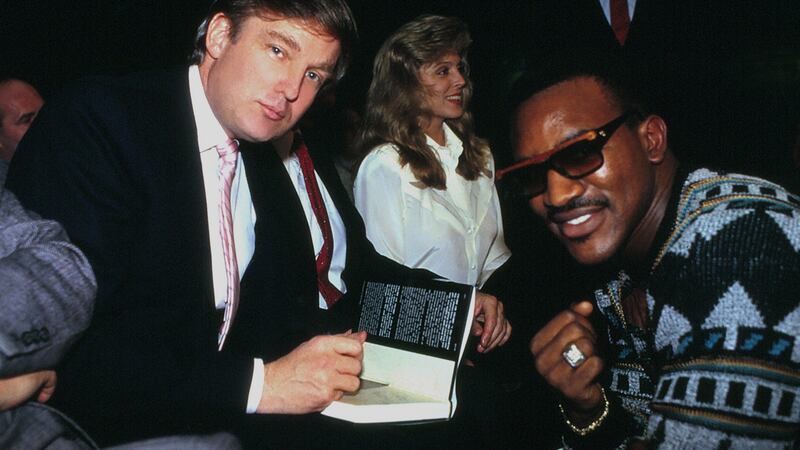 Donald Trump signs his book The Art Of The Deal for boxer Evander Holyfield in Atlantic City, New Jersey in 1989. Photograph:  Jeffrey Asher/ Getty Images