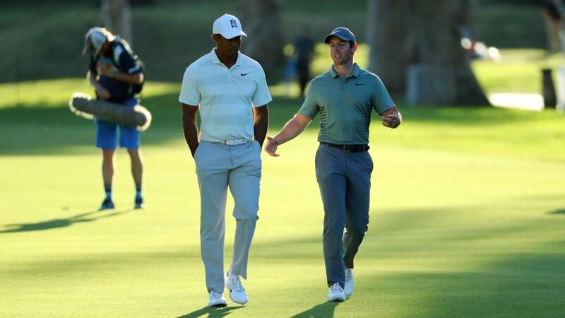 Woods and McIlroy walk down the 17th fairway as the sun sets. Photo: Warren Little/Getty Images
