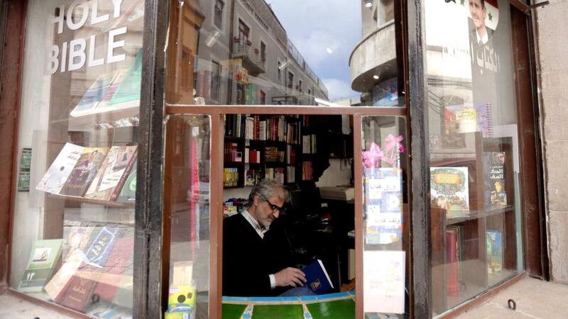 A Syrian man reads inside a bookshop in the old city of Damascus. Four years into Syria’s civil war, Damascus, an ancient oasis, has replaced Aleppo, divided and humbled by fighting, as the country’s commercial hub. Photograph: Louai Beshara/AFP/Getty Images