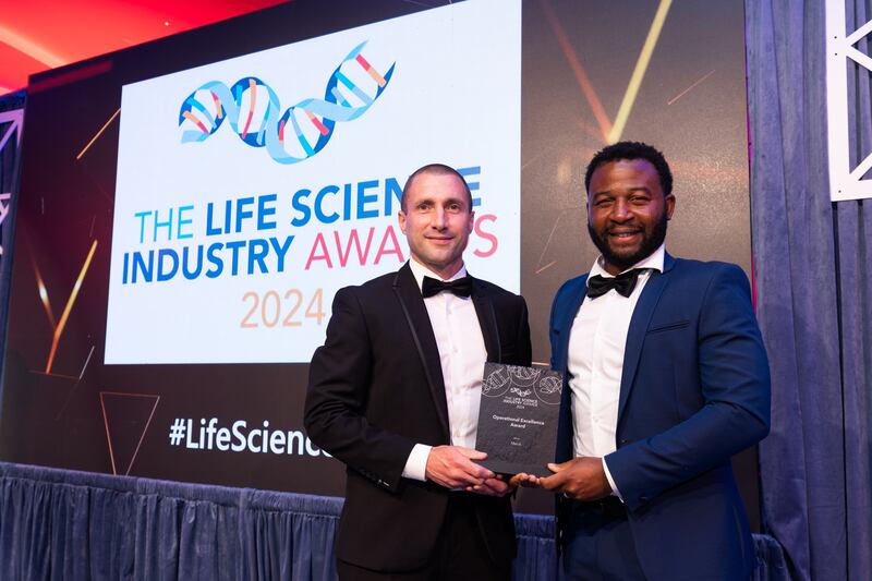 Michael Brennan, sales executive at Controlled Environments Company, presents the operational excellence award to David Iroaganachi, Merck