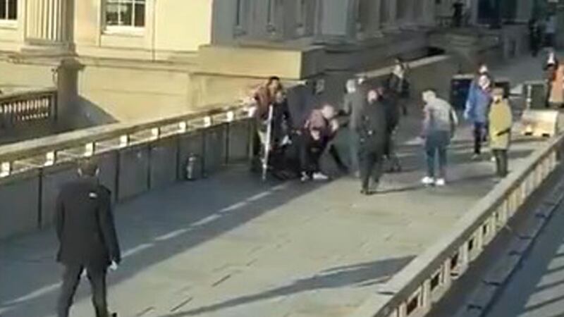 Bystanders surrounding a person at the scene of an incident on London Bridge in central London. Photograph: @HLOBlog/Twitter/PA Wire