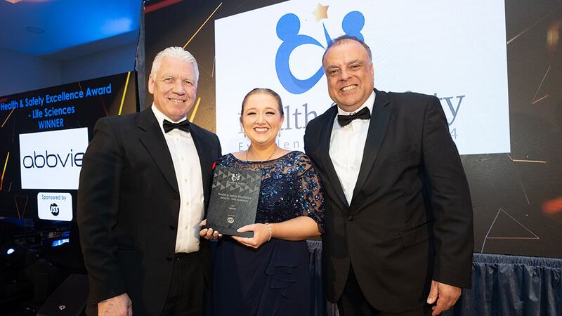 Eric Doyle, managing director at ISS, presents the health & safety excellence award – life sciences to Zoe McConnell & Rocco Alberto Ricci, AbbVie