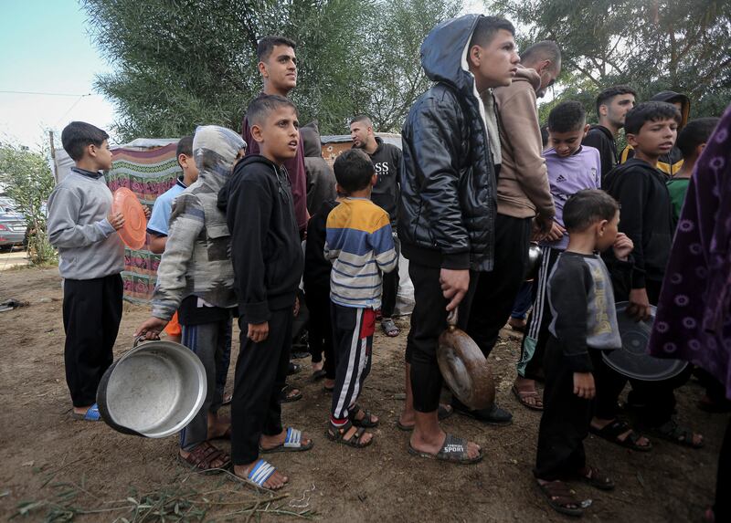 Palestinian children queue to get food in Khan Younis, southern Gaza. Photograph: Yousef Masoud/New York Times
                      