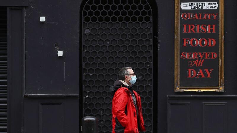 A man passes a closed pub in Dublin’s city centre The Government is to consider on Tuesday new advice from the National Public Health Emergency Team (Nphet) regarding new restrictions on hospitality and household visits. Photograph: PA
